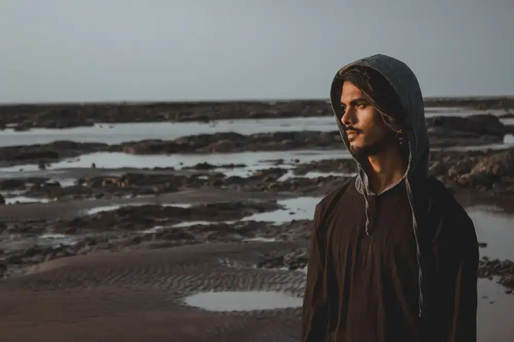 Person wearing a cozy Saltline hoodie at the beach