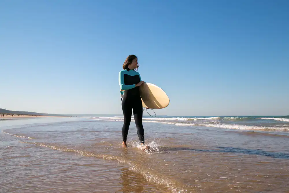 Surfer holding a board wearing new season swimwear